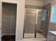 A glass shower with a tiled wall and a built-in seat next to a closet at 2915 Noritake Trl # 71, Albemarle, NC 28001