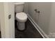 This half bath features a toilet with black floors and white trim at 2915 Noritake Trl # 71, Albemarle, NC 28001