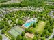 Beautiful aerial view of community pool, tennis courts and homes surrounded by trees on a sunny day at 3110 Streamside Dr, Davidson, NC 28036