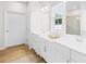Bright bathroom featuring double vanities, white cabinets, modern fixtures, and a glass-enclosed shower at 3110 Streamside Dr, Davidson, NC 28036