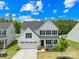 Charming two-story white home with a two car garage, landscaped yard, and covered front porch at 3110 Streamside Dr, Davidson, NC 28036