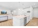Bright, all-white kitchen with stainless steel appliances and a large island, seamlessly flowing into the living area at 3110 Streamside Dr, Davidson, NC 28036