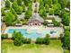 Aerial view of a community pool and clubhouse surrounded by lush green trees at 3110 Streamside Dr, Davidson, NC 28036