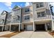 Beautiful townhome exterior showcasing a two-car garage, and a well-manicured front yard with fresh landscaping at 3124 Butler Hill Dr, Matthews, NC 28105