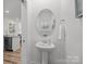 Stylish powder room featuring a pedestal sink and a round mirror at 3128 Butler Hill Dr, Matthews, NC 28105