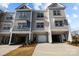 A row of modern townhomes featuring eye-catching facades and attached garages, creating an inviting neighborhood street view at 3128 Butler Hill Dr, Matthews, NC 28105