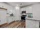 Modern white kitchen with stainless steel appliances, granite countertops, and sleek wood flooring at 3128 Butler Hill Dr, Matthews, NC 28105