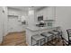 Modern white kitchen with stainless steel appliances, granite countertops, a breakfast bar and wood flooring at 3128 Butler Hill Dr, Matthews, NC 28105