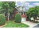 Charming brick home featuring a two-car garage, dormer windows, and a lush, landscaped front yard at 3128 Ethereal Ln, Charlotte, NC 28226