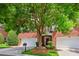 Red brick home featuring a three-car garage, mature shade trees and manicured landscaping at 3128 Ethereal Ln, Charlotte, NC 28226