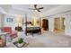 Large main bedroom featuring a tray ceiling, four-poster bed, and sitting area at 3128 Ethereal Ln, Charlotte, NC 28226