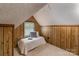 Cozy attic bedroom with wood paneling and a small window for natural light at 328 E Center Ave, Mooresville, NC 28115