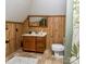Functional bathroom featuring wood paneling, a vanity with storage, and a toilet with shower at 328 E Center Ave, Mooresville, NC 28115