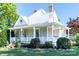 Charming home showcasing a inviting front porch, landscaped yard, and architectural details under a clear blue sky at 328 E Center Ave, Mooresville, NC 28115