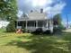 Charming home featuring a cozy front porch, mature landscaping, and a well-maintained lawn at 328 E Center Ave, Mooresville, NC 28115