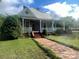 Charming home featuring a cozy front porch, brick steps, and mature landscaping at 328 E Center Ave, Mooresville, NC 28115