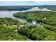 Aerial shot of a lakeside property nestled among lush trees and the expansive lake at 335 Whisper Lake Dr, New London, NC 28127