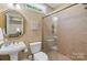 Charming bathroom with pedestal sink, glass shower, and vintage-inspired decor at 335 Whisper Lake Dr, New London, NC 28127