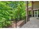 Covered porch with black metal railings offering stunning views of lush greenery at 335 Whisper Lake Dr, New London, NC 28127