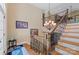 Grand staircase with wood steps, ornate iron railings, and chandelier lighting at 335 Whisper Lake Dr, New London, NC 28127