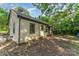 The back side of a single-story home with siding, showcasing its backyard and a covered porch at 3924 Tillman Rd, Charlotte, NC 28208
