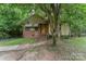 Charming brick and siding home with covered porch and mature trees in a secluded setting at 3924 Tillman Rd, Charlotte, NC 28208