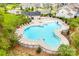 A unique and inviting community pool with lounge seating and shade umbrellas surrounded by trees and fencing at 4023 Spring Garden St, Fort Mill, SC 29715