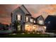 Twilight front exterior view of a charming two-story home, featuring a well-lit front yard and garage at 4023 Spring Garden St, Fort Mill, SC 29715