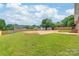 This backyard features a large grassy area, wooden fencing, and mature trees at 405 W Ormand Ave, Bessemer City, NC 28016
