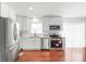Bright kitchen featuring stainless steel appliances, white cabinetry, and hardwood floors at 405 W Ormand Ave, Bessemer City, NC 28016
