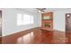 Bright living room features hardwood floors, a brick fireplace, and a large window at 405 W Ormand Ave, Bessemer City, NC 28016