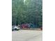 Colorful playground in a park surrounded by trees and a parking lot with cars at 405 W Ormand Ave, Bessemer City, NC 28016