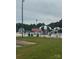 A community pool surrounded by a grassy field with trees, beach umbrellas, and lounge chairs at 405 W Ormand Ave, Bessemer City, NC 28016