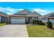 Charming single-story home with a two car garage and a well-manicured front yard under a blue sky at 4243 Merrivale Dr, Lancaster, SC 29720