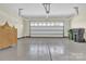 Garage with concrete floors and a white garage door, trash cans and a wooden cabinet at 4243 Merrivale Dr, Lancaster, SC 29720