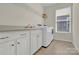 Laundry room with white washer and dryer, white cabinets and a window at 4243 Merrivale Dr, Lancaster, SC 29720