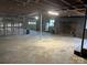 Unfinished basement with concrete floor, exposed ceiling, shelving, and a brick fireplace at 4268 Wilkesboro Hwy, Statesville, NC 28625