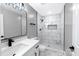 Modern bathroom featuring marble tile, a sleek vanity, and a glass-enclosed shower with stylish black fixtures at 4914 Ridgeley Dr, Charlotte, NC 28208