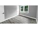 Cozy bedroom with gray walls, wood-look flooring, and natural light from the bright window at 4914 Ridgeley Dr, Charlotte, NC 28208