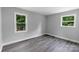 Comfortable bedroom featuring wood-look floors, gray walls, and well-lit windows with peaceful outdoor views at 4914 Ridgeley Dr, Charlotte, NC 28208
