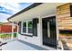 Close up of front door with black frame, stone and white brick exterior, and gray painted deck at 4914 Ridgeley Dr, Charlotte, NC 28208