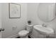 Bathroom featuring a sleek pedestal sink, toilet, and framed botanical wall art at 5004 Cherry Gum Ct # 43, Matthews, NC 28105