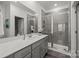 Modern bathroom featuring a spacious vanity, large mirror, and a glass-enclosed shower with gray tiling at 5004 Cherry Gum Ct # 43, Matthews, NC 28105