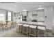 Kitchen with gray island, white cabinetry, stainless appliances, and dining table at 5030 Grain Orchard Rd # 3025C, Indian Trail, NC 28079