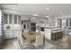 Open-concept kitchen features white cabinets, stainless steel appliances, and a spacious island with bar seating at 5030 Grain Orchard Rd # 3025C, Indian Trail, NC 28079