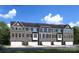 Exterior shot of gray stone and siding townhomes with individual garages and landscaping at 5030 Grain Orchard Rd # 3025C, Indian Trail, NC 28079