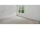 Comfortable bedroom with neutral carpet and a large window providing natural light at 6322 Sydney Mae Ln, Charlotte, NC 28262
