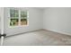 Cozy bedroom featuring a large window offering a view of a fenced-in green yard at 6322 Sydney Mae Ln, Charlotte, NC 28262