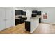 Well-lit kitchen with black cabinets, an island, and sleek appliances at 6322 Sydney Mae Ln, Charlotte, NC 28262