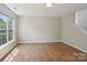 Sunny room with wood-look flooring, large window, and staircase access at 6332 Sackett Way, Charlotte, NC 28269